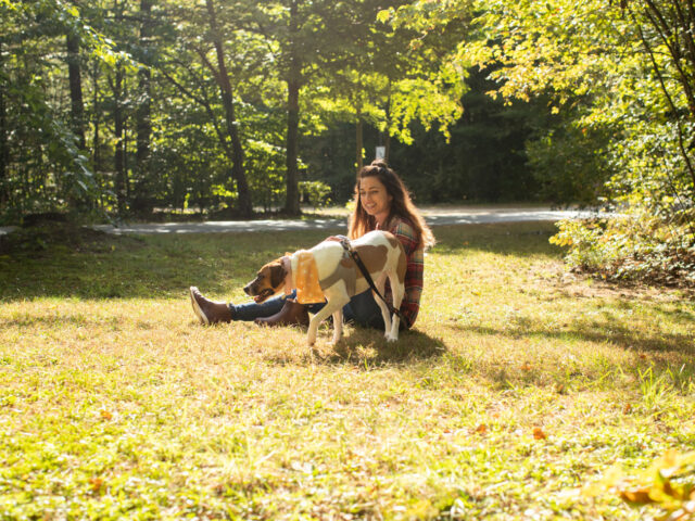 A woman and a dog together outside.