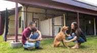 Two people and a dog in an outdoor MHS facility.