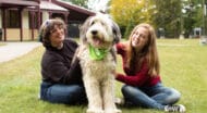 two young women petting a dog.