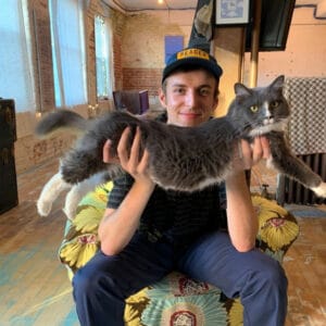 A person holding a gray cat.