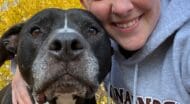 woman smiling with her dog.