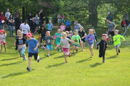 A group of young students running outside.