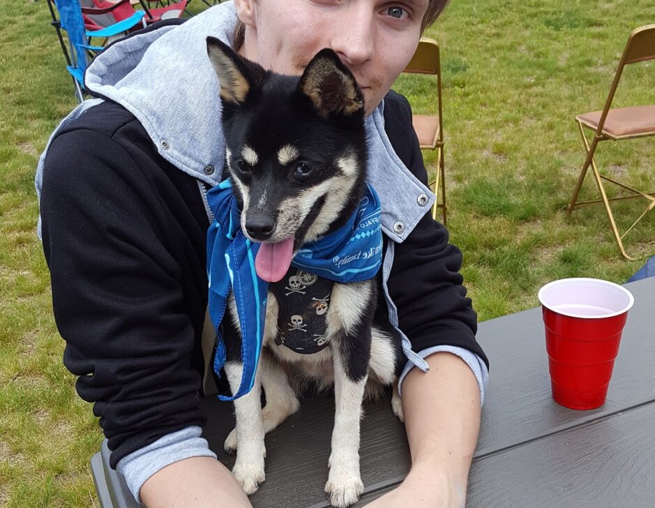 man with his small puppy on a table.