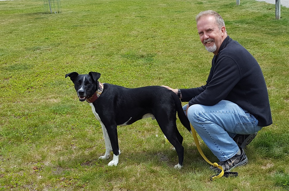 black dog with his owner outside.