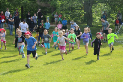 A group of young students running outside.