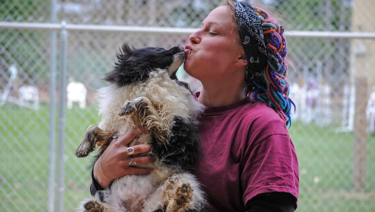 A MHS staff member holding a dog in their arms.