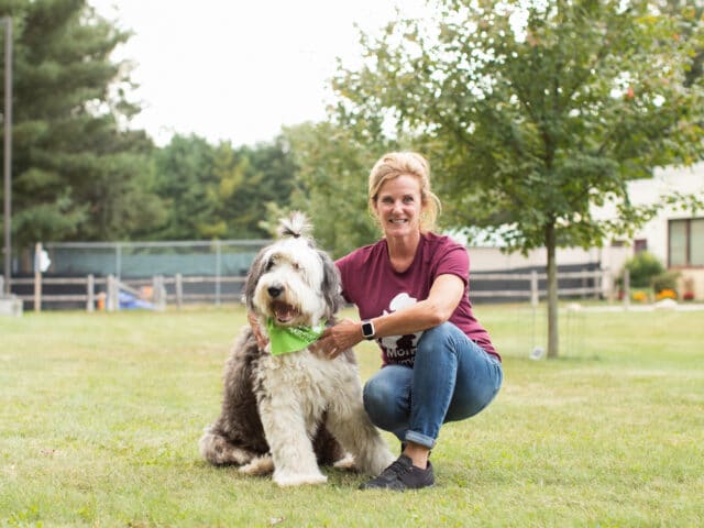 A MHS staff member with a dog outside.