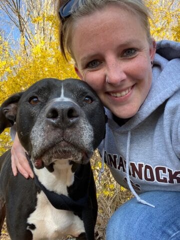 woman smiling with her dog.